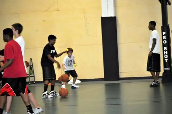 A dribbling drill with a coach on the old floor