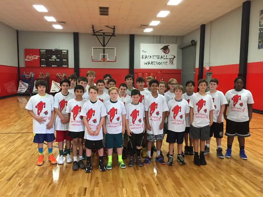 A summer camp group lined up on the hardwood in matching camp shirts