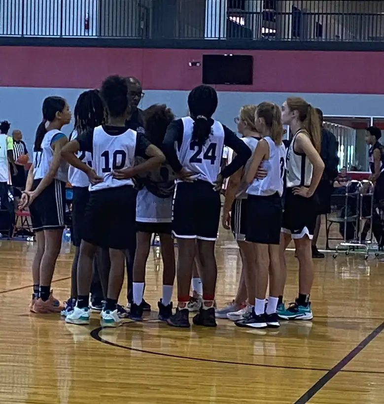 A middle school girls team in a huddle