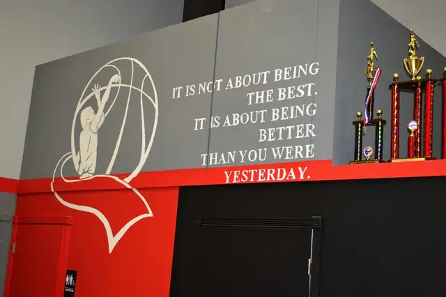Gym wall mural reading: it is not about being the best, it is about being better than you were yesterday